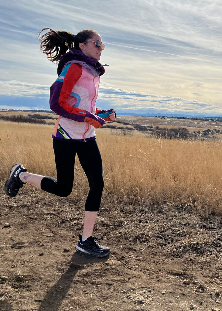 Person running on a dirt path with a scenic background